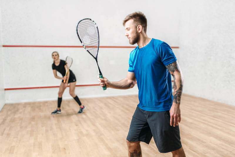 active-couple-with-rackets-play-squash-game