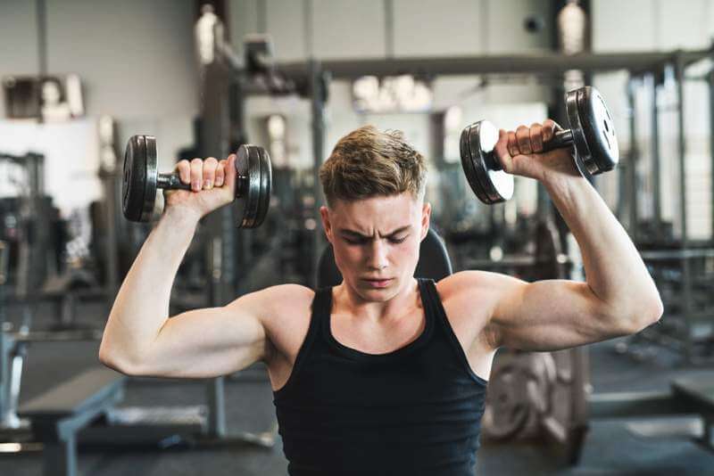 young-fit-man-in-gym-exercising-with-dumbbells