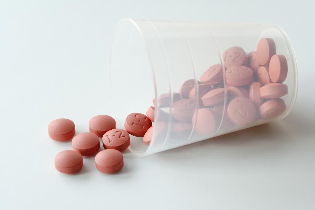 Ibuprofen pills in plastic cup