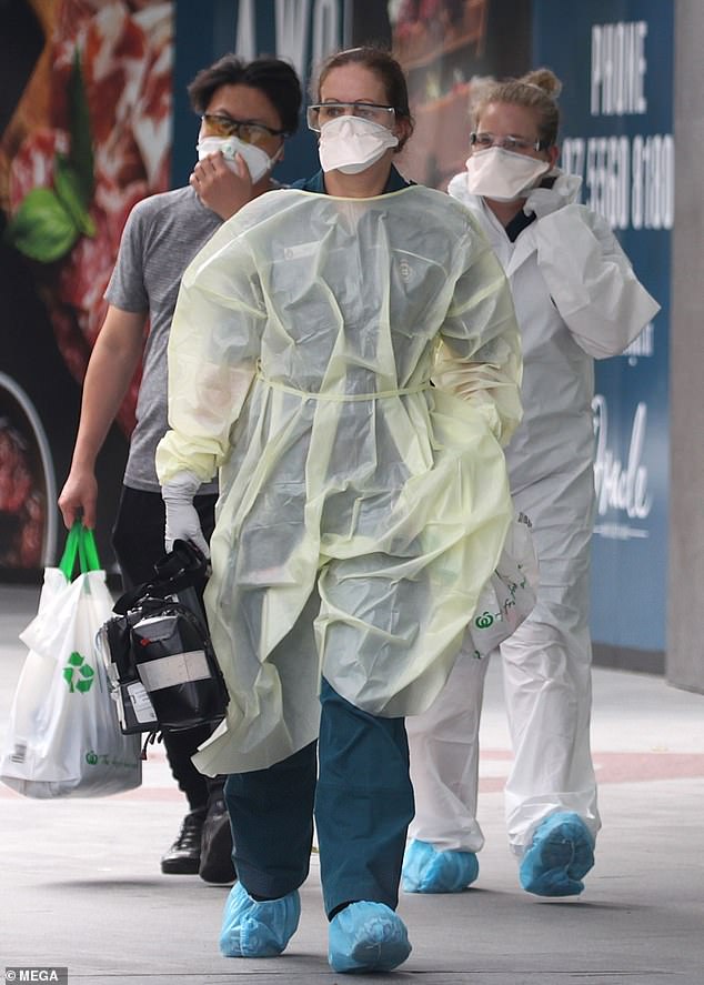 Paramedics wearing hazmat suits arrived in Broadbeach, Australia, to reports of a suspected coronavirus case on Tuesday – they are pictured escorting the male patient out to an ambulance