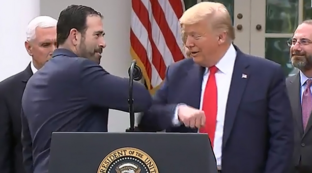 Bruce Greenstein of LHC Group gives President Trump an elbow bump during a press conference on Friday.