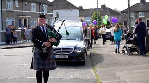 A lone piper leads the cortege for Robyn&rsquo;s funeral mass
